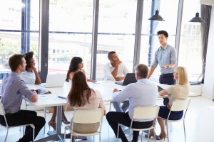 A newly formed startup company sits around a table collaborating.