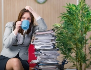 woman sitting next to a stack of paperwork