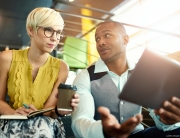 woman in yellow talk to man with tablet pc